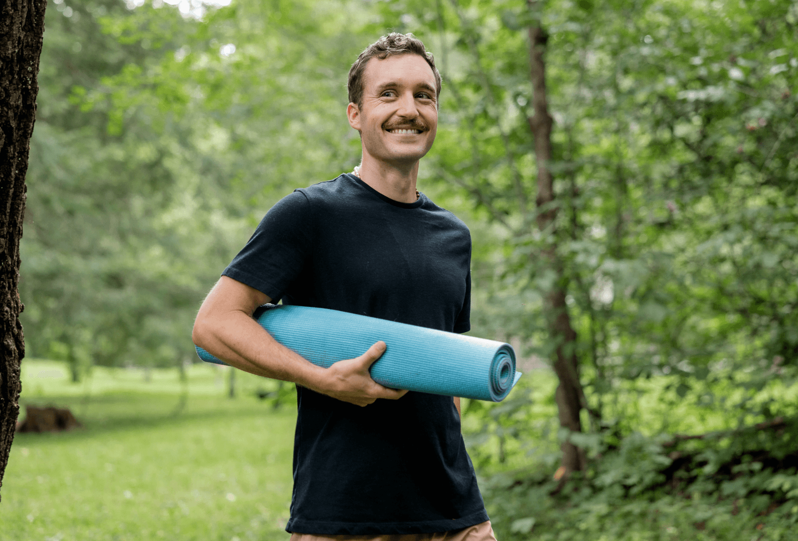 Dr. Cameron with yoga mat in nature